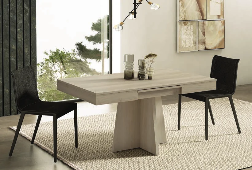 Pale dining table with a central support and dark chairs